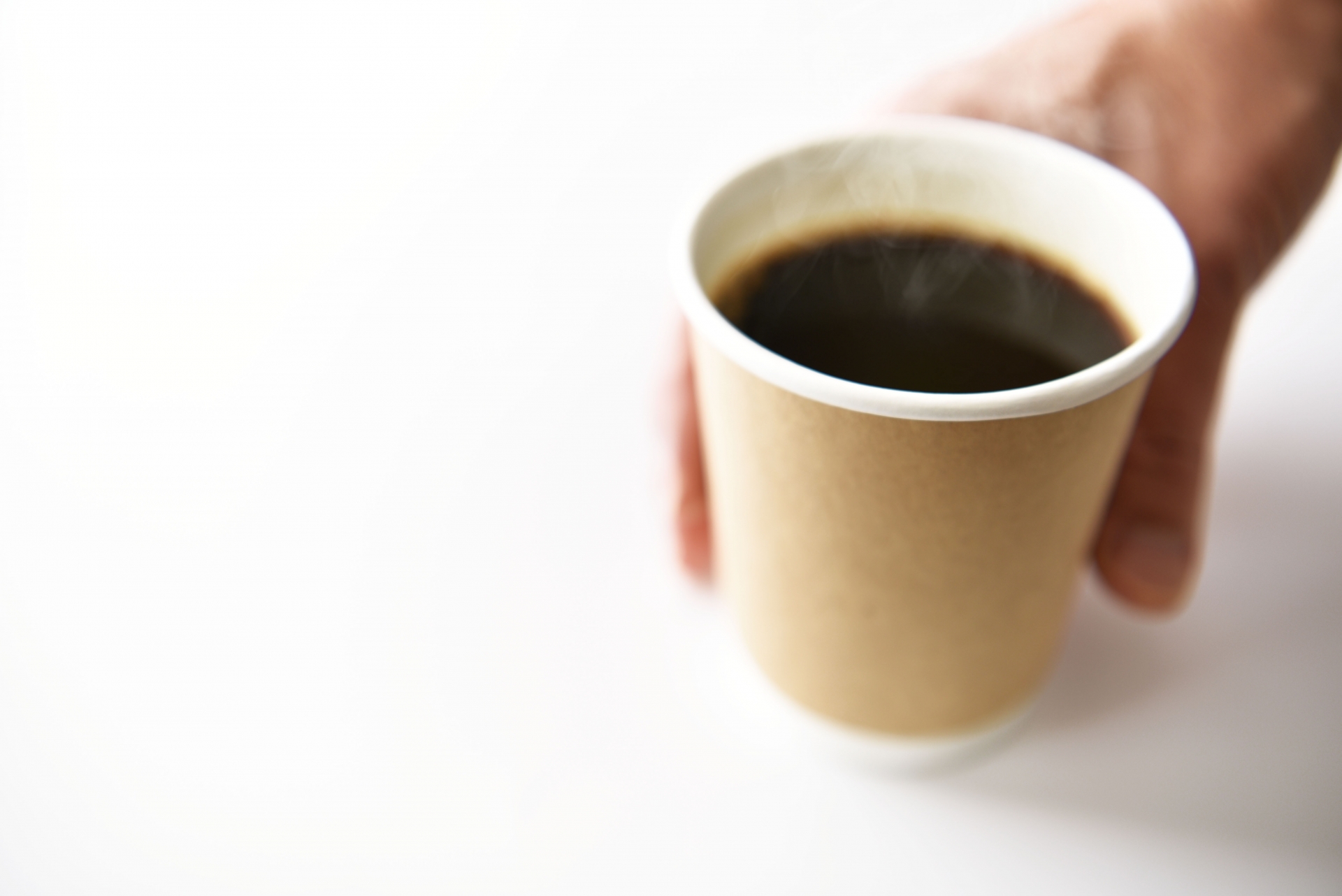 コーヒーカップを差し出すコンビニ店員